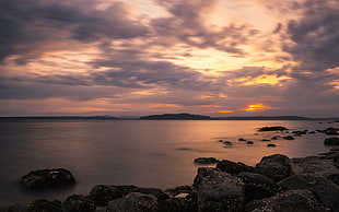 rock formation near ocean water during yellow sunset HD wallpaper