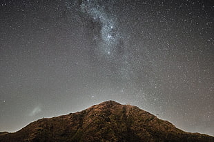 photo mountain with stars during night time