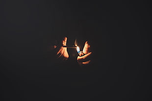 pair of gold-colored earrings, hands, lighter, fire