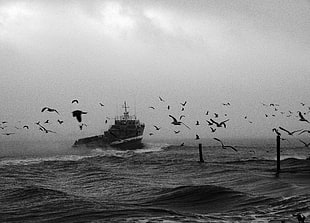 grey scale photo of ship on sea under dark sky