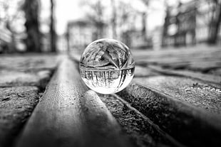 grayscale photography of glass ball on canal