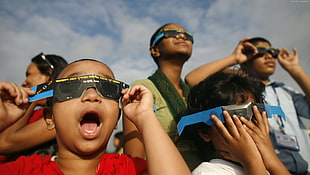 four children wearing eclipse sunglasses HD wallpaper