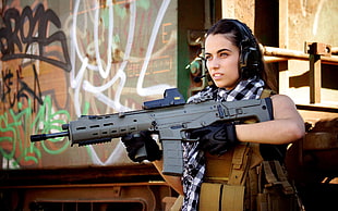 woman holding grey and black FN SCAR rifle