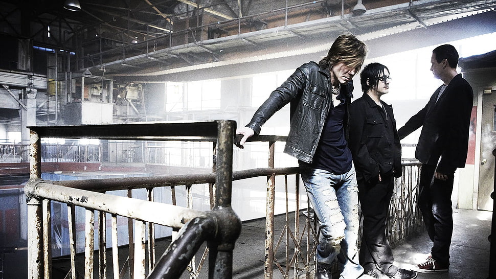 three men band members standing beside brown metal handrails HD wallpaper