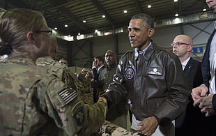 Barack Obama shaking hands with woman in camouflage jacket