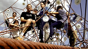 seven man standing on cage themed structure