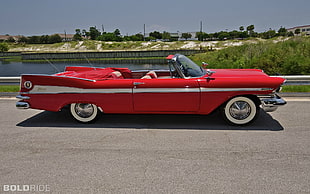 classic red convertible coupe on grey concrete road during daytime