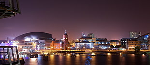 lighted buildings near body of water during night time, cardiff