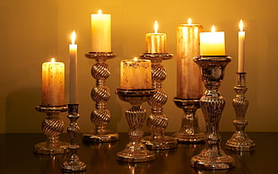 brown candle holders near yellow wall