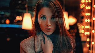 shallow focus photography of woman in brown coat