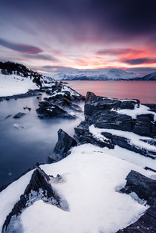 time-lapse photography of snowy hills and body of water during golden hour, ullsfjord, norway