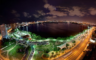 aerial photo of calm body of water between city skyline at nighttime