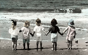five Girls's holding their hands in the seashore grayscale portrait