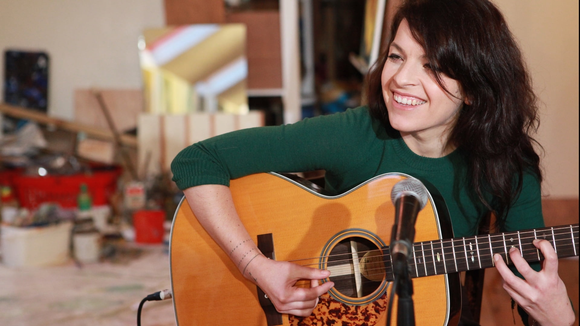 woman playing guitar in front of microphone