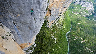 person in green shirt climbing on cliff HD wallpaper