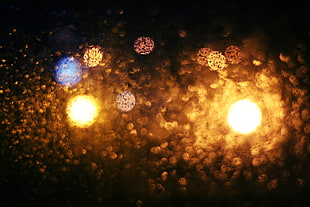 photography of yellow and blue bokeh lights while raining during nighttime