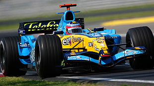 shallow focus photography of person riding blue and yellow F1