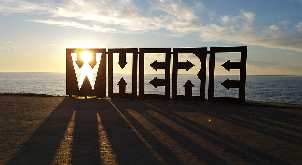 where standee on brown sand beside ocean during daytime HD wallpaper