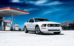 white Ford Mustang near on gas station