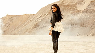 woman in black and white long-sleeved shirt standing on desert
