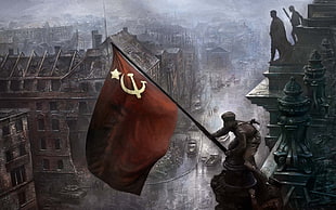 person raising hammer and sickle flag on top of building