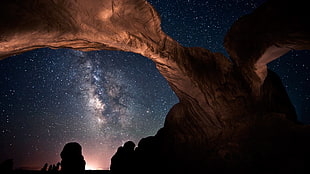 brown rock formation under starry sky HD wallpaper