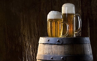 two clear glass beer mugs, beer, foam, wall, barrels