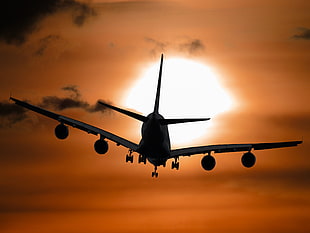 Silhouette of airplane during sunset