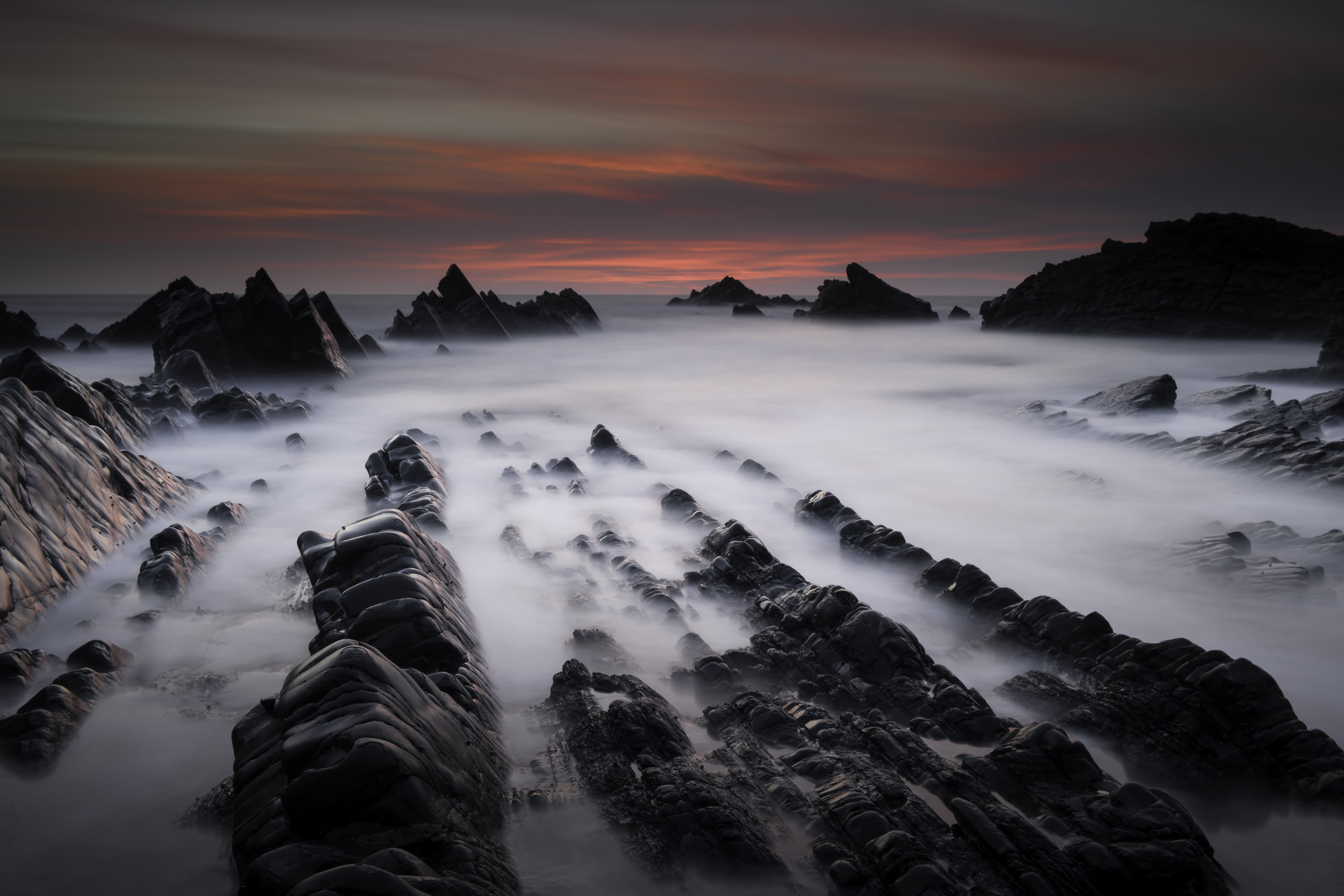 timelapse photography of rocky mountain covered by sea of clouds during sunset, hartland quay