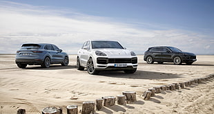three white, blue, and black vehicles on sand during daytime HD wallpaper