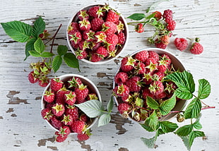 raspberry fruits filled white bowls