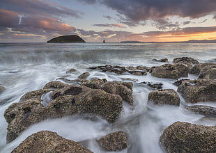 timelapse landscape photography of body of water rushing on stones, penmon, anglesey
