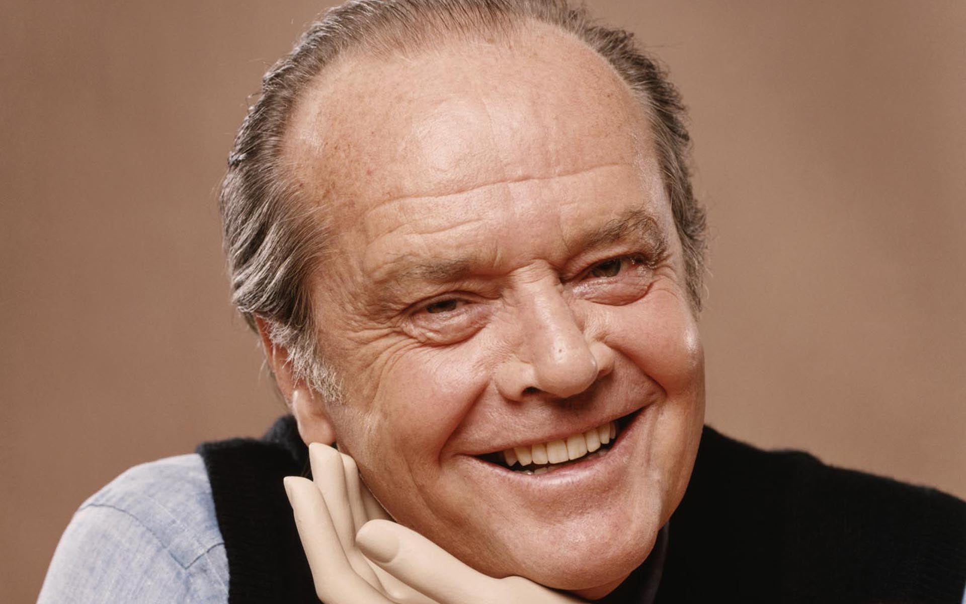 man in black and gray shirt smiling holding his face