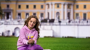 girl sitting on green grass field during daytime