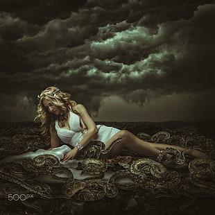 woman in white dress surrounded by brown snakes