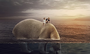 girl and boy riding polar bear on body of water photo