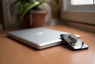 black smartphone beside MacBook Proo