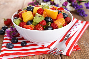 closeup photo of variety of sliced fruits in white ceramic bowl