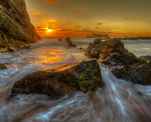 timelapse photography of sea with mountain during golden hour HD wallpaper