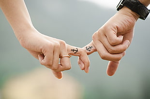 selective focus photo of couple with anchor tattoo