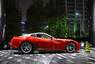 red Ferrari coupe parked near building