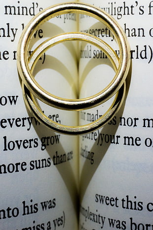 two silver rings on book page HD wallpaper