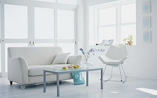 rectangular glass top coffee table near white loveseat on living room