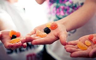 three hands holding jelly candies