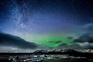 Northern Lights over snow covered mountain during night, iceland