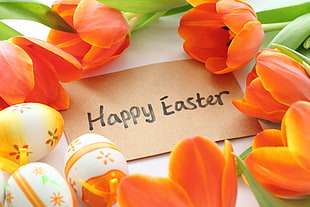 Happy Easter Egg text with brown print paper surrounded of orange tulip flowers