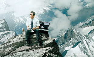 man sitting on mountain peak HD wallpaper