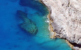 aerial photo of rocky cliff near large body of water