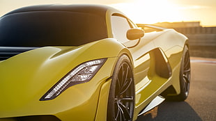 yellow sports coupe parked during golden hour